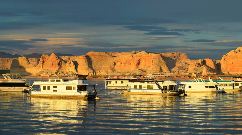 Houseboats floating in a beautiful fjord during sunset, with sunlight reflecting off their exteriors.